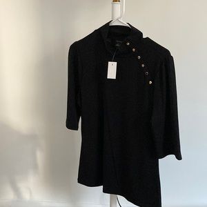 Black knit top with gold button detail on the shoulder. Mock turtle neck.